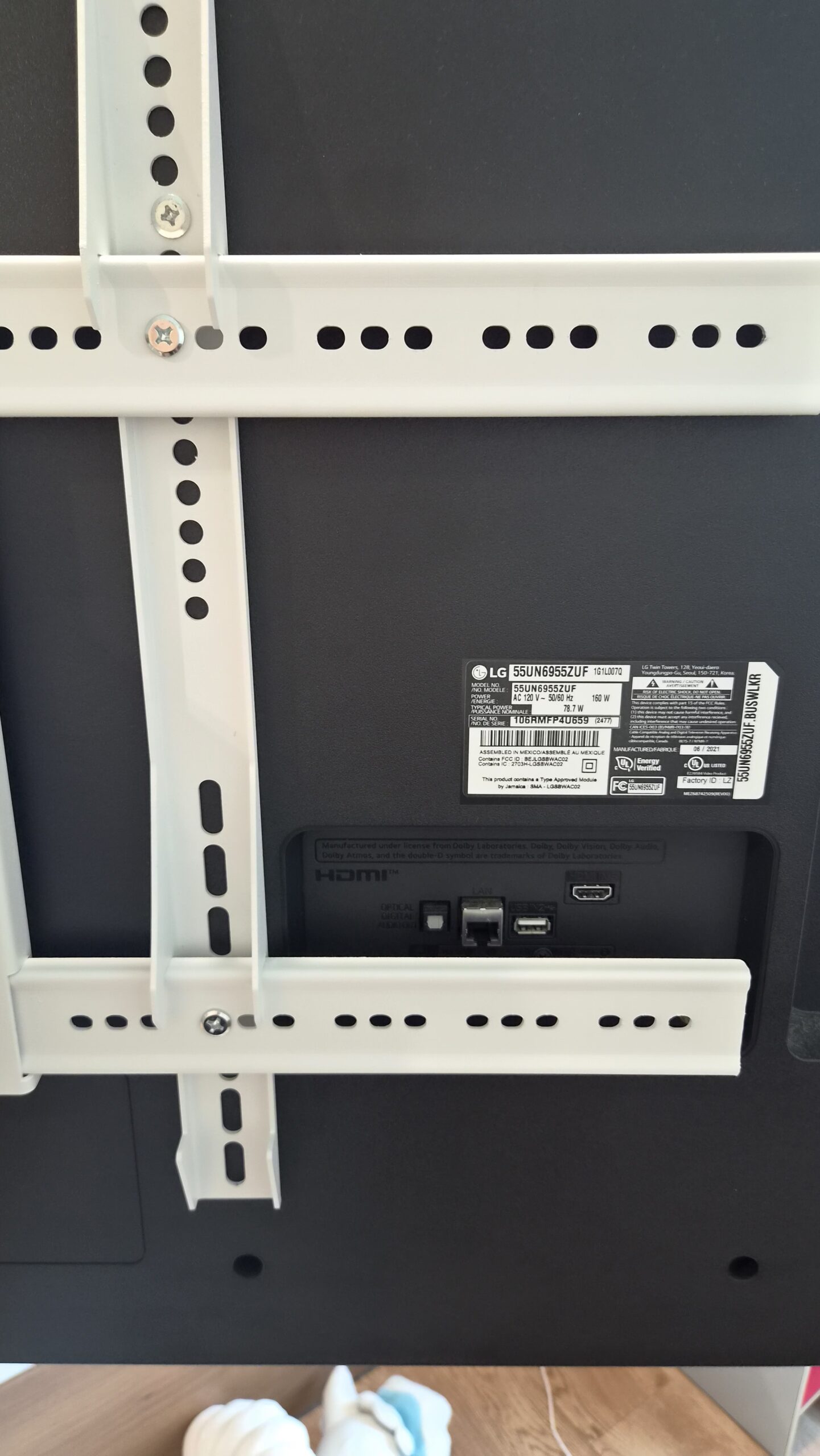 검은 TV 뒷면에 흰 베사 브래킷과 HDMI 단자가 보이는 모습